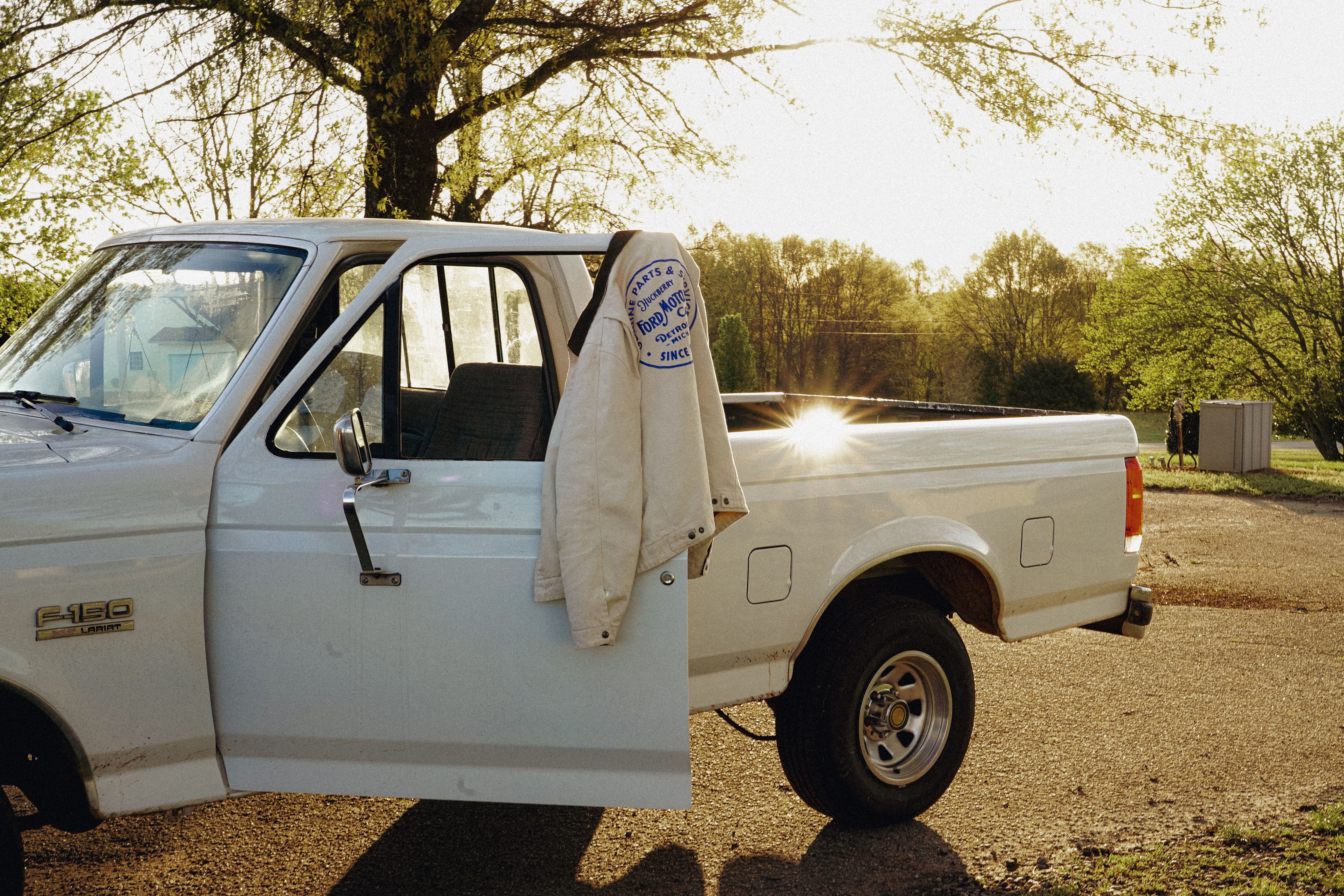 A white Ford truck with a jacket hanging on the door