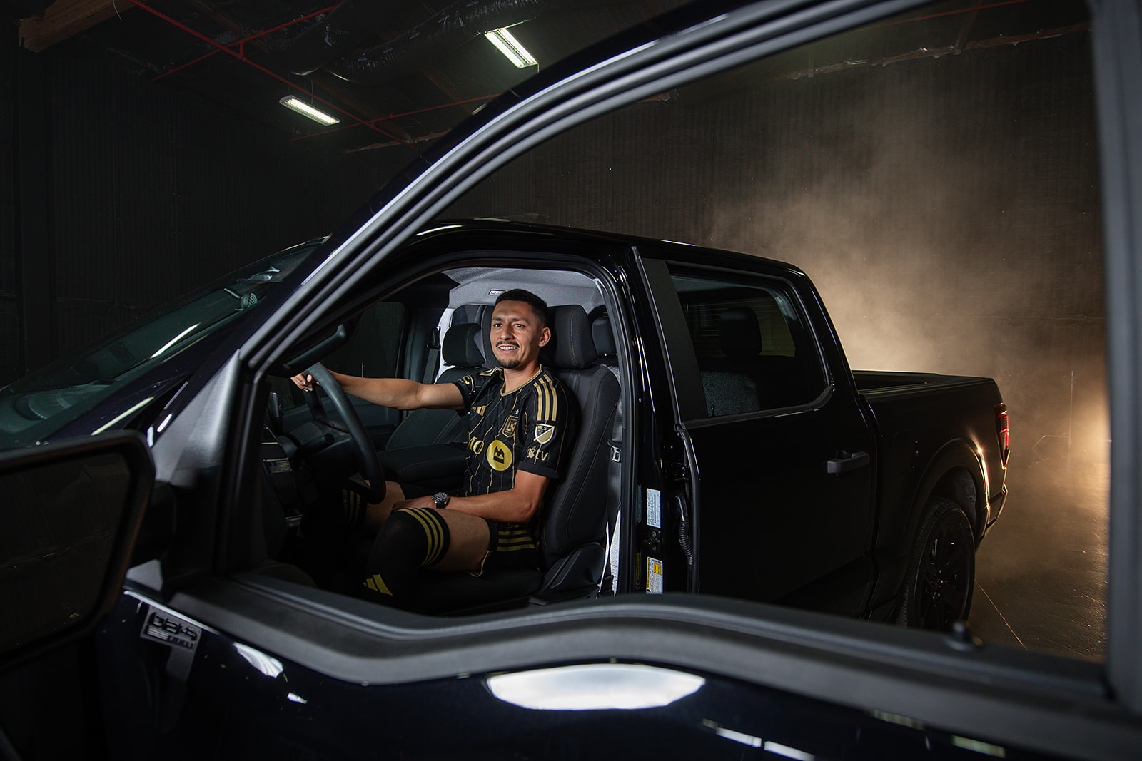 Los Angeles Football Club soccer player Mark Delgado sits behind the wheel of the Ford F-150 Lobo.