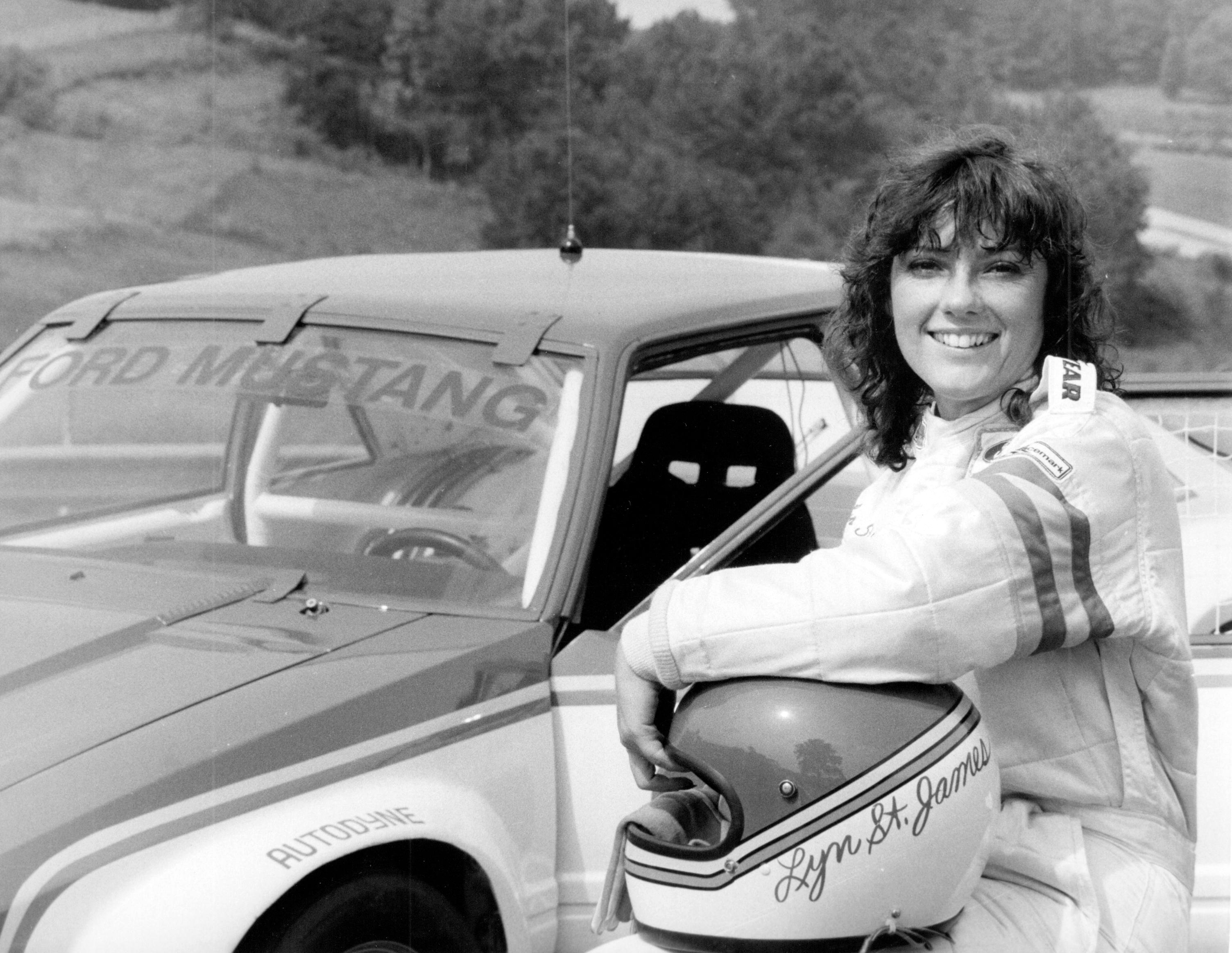 Lyn St. James posing with a Ford Mustang.