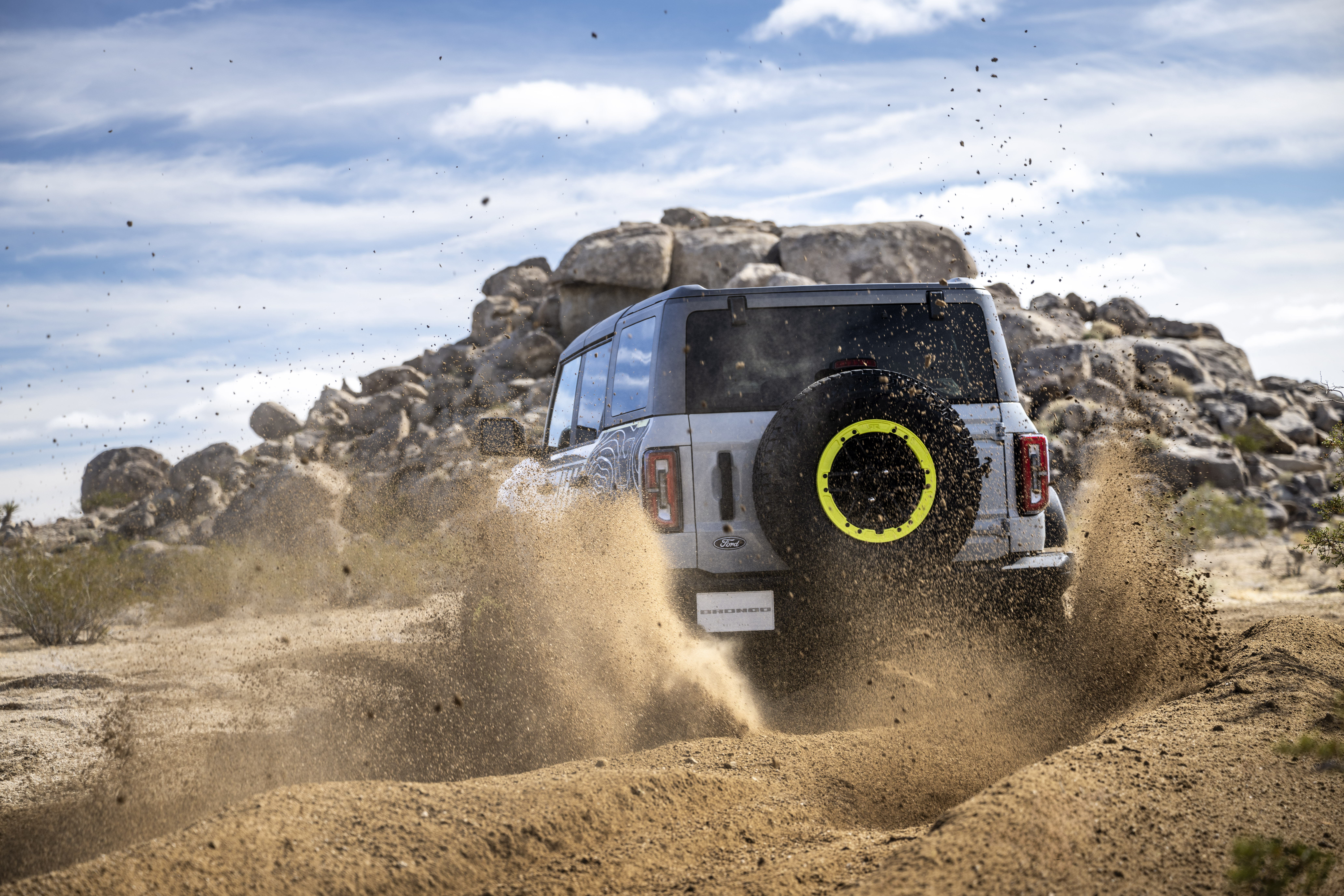 The back of the Bronco RTR, grey with lime green highlights, kicking up dirt