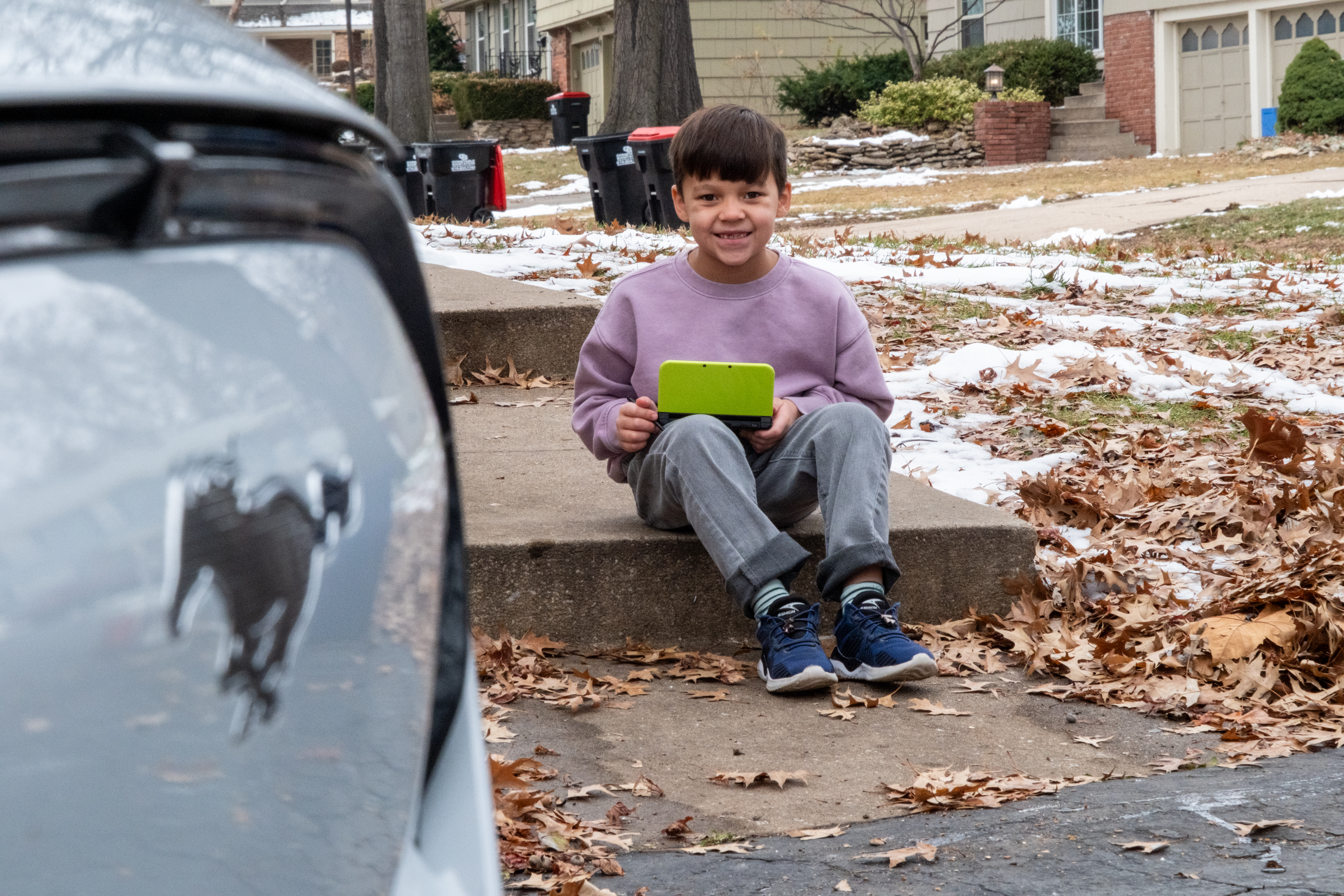 Oliver sitting next to the Mustang Mach-E.